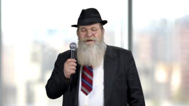 Kendine güvenen politikacı mikrofona konuşuyor.