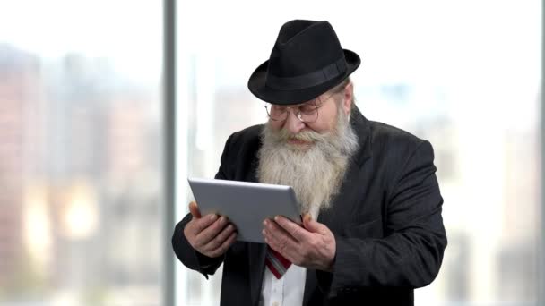Viejo hombre de negocios riendo mirando tableta digital. — Vídeo de stock