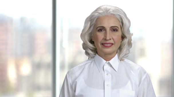 Retrato de mulher idosa feliz no fundo borrado. — Vídeo de Stock