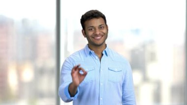 Gülümseyen genç adam işaret veriyor..