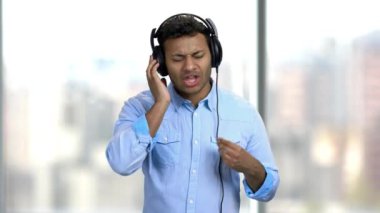 Neşeli adam kulaklıkla müzik dinliyor..