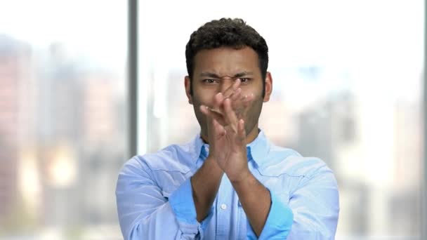 Giovane uomo indiano smorfia su sfondo sfocato. — Video Stock