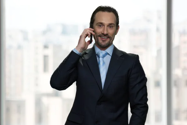 Χαμογελώντας ώριμος επιχειρηματίας μιλώντας στο κινητό τηλέφωνο. — Φωτογραφία Αρχείου