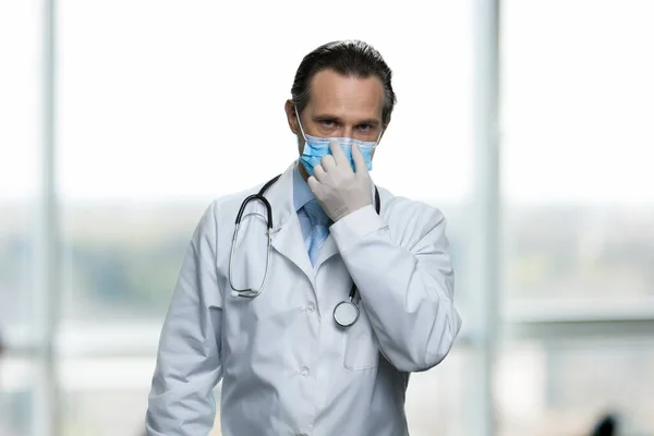 Man läkare i handskar justera medicinsk mask. — Stockfoto