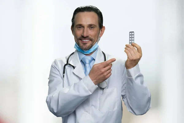Man Kaukasische arts tonen pillen op witte achtergrond. — Stockfoto