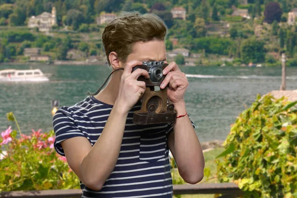 Tourist boy using vintage camera on sea background. — Stock Photo, Image