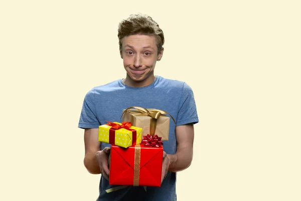 Vicces tini fiú kínál ajándék dobozok. — Stock Fotó