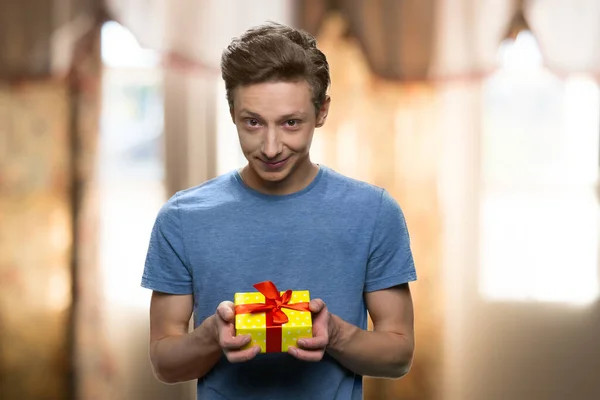 선물 상자를 들고 있는 수줍어 하는 코카서스 소년의 모습. — 스톡 사진
