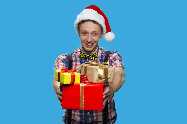 Funny teenage guy handing Christmas gift boxes. — Stock Photo, Image