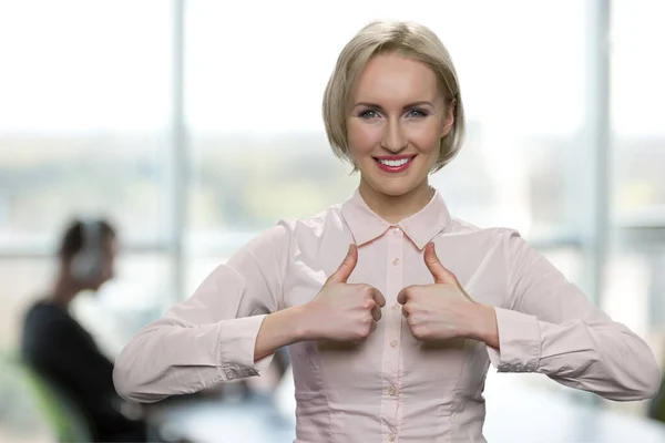 Obchodní žena ukazuje palce nahoru na kameru. — Stock fotografie