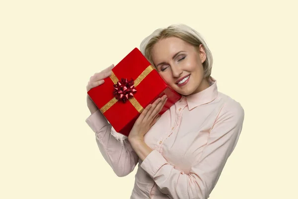 Feliz mulher loira abraçando embrulhado caixa de presente. — Fotografia de Stock