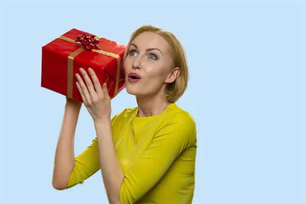 Giovane donna gioiosa ascolto scatola regalo. — Foto Stock