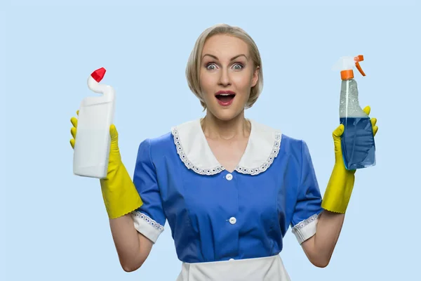 Feliz chocado empregada doméstica mulher apresentando suprimentos de limpeza. — Fotografia de Stock