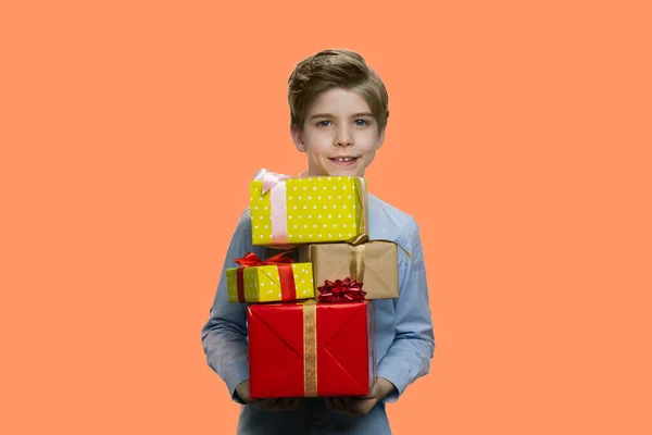 Bonito menino sorridente segurando caixas de presente . — Fotografia de Stock