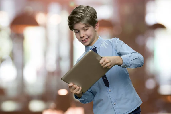 Enthusiastic caucasian boy playing game on digital tablet.