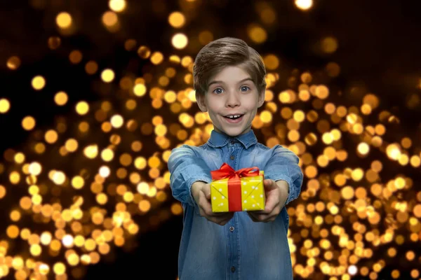 Lindo niño alegre entrega caja de regalo a la cámara. — Foto de Stock