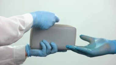 Eldivenli kişi, eldivenli diğer kişiye madeni para verir..