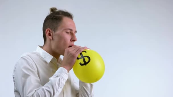 Mann bläst Luftballon mit dem Symbol eines Dollars. — Stockvideo