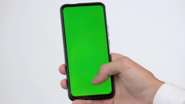 Mano del hombre utilizando el teléfono inteligente con pantalla de clave de croma verde. — Vídeo de stock