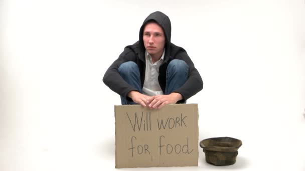 Sad young man holding poster Will work for wood. — Stock Video