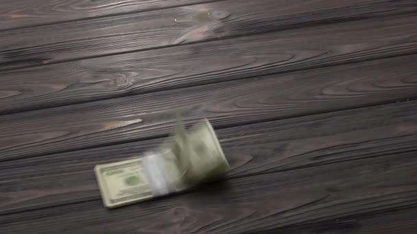 Δέσμη δολαρίων που πέφτουν στο ξύλινο τραπέζι. — Αρχείο Βίντεο