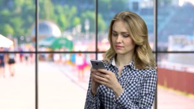 Genç ve güzel bir kadın cep telefonunda uygulama kullanıyor..