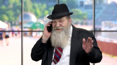 Kıdemli tüccar ya da işadamı cep telefonuyla konuşuyor..