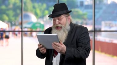 Son sınıf öğrencisi elinde dijital tabletle gülüyor..