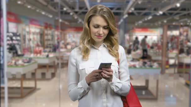Молода жінка робить покупки через Інтернет за допомогою смартфона . — стокове відео