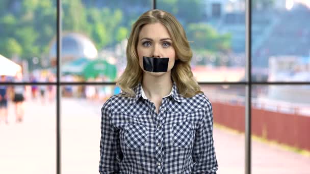 Young caucasian woman with black tape over mouth. — Stock Video