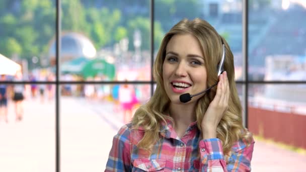 Operador de call center bonito com fone de ouvido conversando com alguém. — Vídeo de Stock
