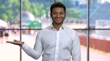 Yakışıklı işadamı ürün için yer gösteriyor..