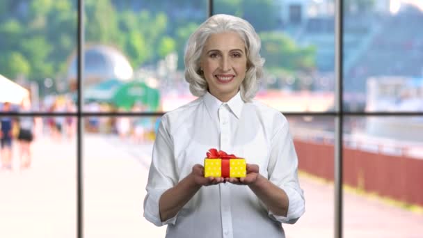 Reife Geschäftsfrau bietet Geschenkbox an. — Stockvideo