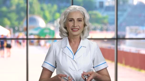 Woman doctor puts on stethoscope. — Stock Video