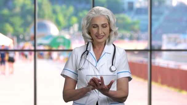 Médico femenino usando tableta digital transparente. — Vídeo de stock