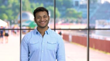 Pencerelerde bir şey gösteren gülümseyen genç adam..