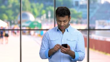 Genç yakışıklı adam akıllı telefonuyla başvuru yapıyor..