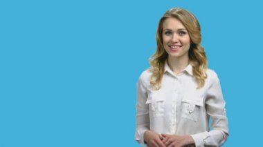 Mavi arka planda telif alanı gösteren mutlu gülümseyen kadın.