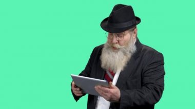 Tablet bilgisayarına bakan heyecanlı sakallı iş adamı.