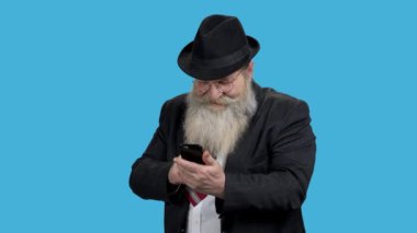 Olgun iş adamı cep telefonuna bakıyor.