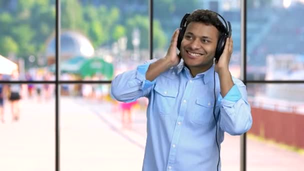 Knappe man geniet van het luisteren naar muziek in hoofdtelefoon. — Stockvideo