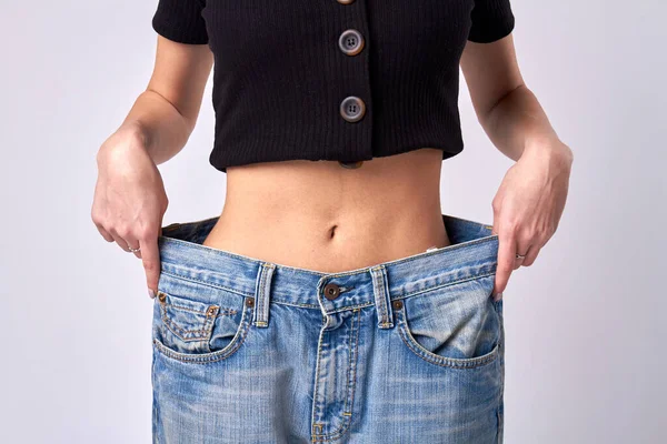 Стройная девушка в огромных джинсовых штанах. — стоковое фото