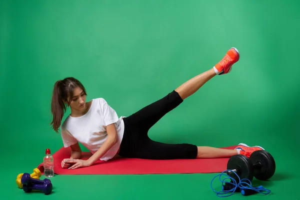 Aktiv amerikansk flicka gör övningar för ben muskler. — Stockfoto