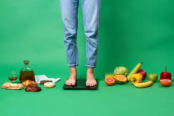 Jambes de femmes sur écailles isolées sur fond vert. — Photo