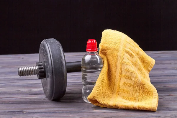 Bottle of water with dumbbell and towel. — Stock Photo, Image