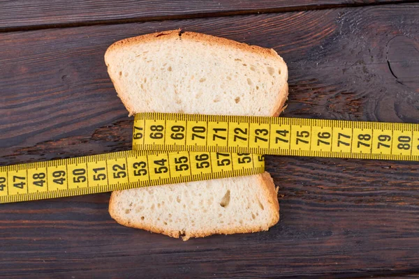 Piece of bread with measure tape. — Stock Photo, Image