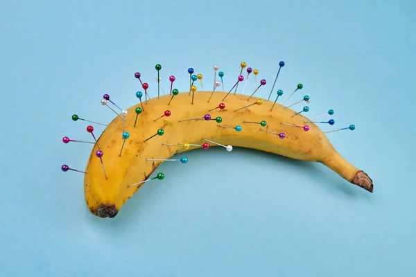 La banane est recouverte de broches à coudre. — Photo