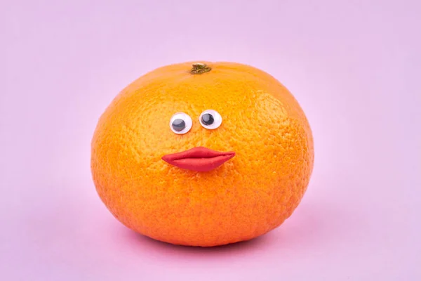 Dojrzała pomarańcza ze śmieszną kobiecą twarzą. — Zdjęcie stockowe