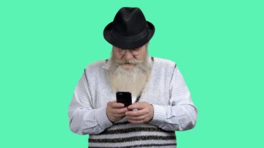 Cep telefonunda internette sörf yapan son sınıf öğrencisinin portresi.