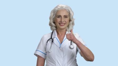 Gülümseyen kadın doktor başparmağını kesiyor..